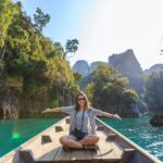 photo of woman sitting on boat spreading her arms