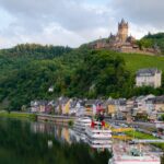 castle on hill over village near body of water